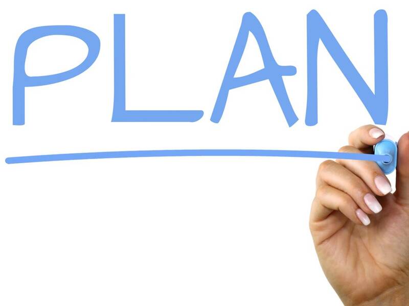 Hand mit Stift unterstricht das Wort Plan